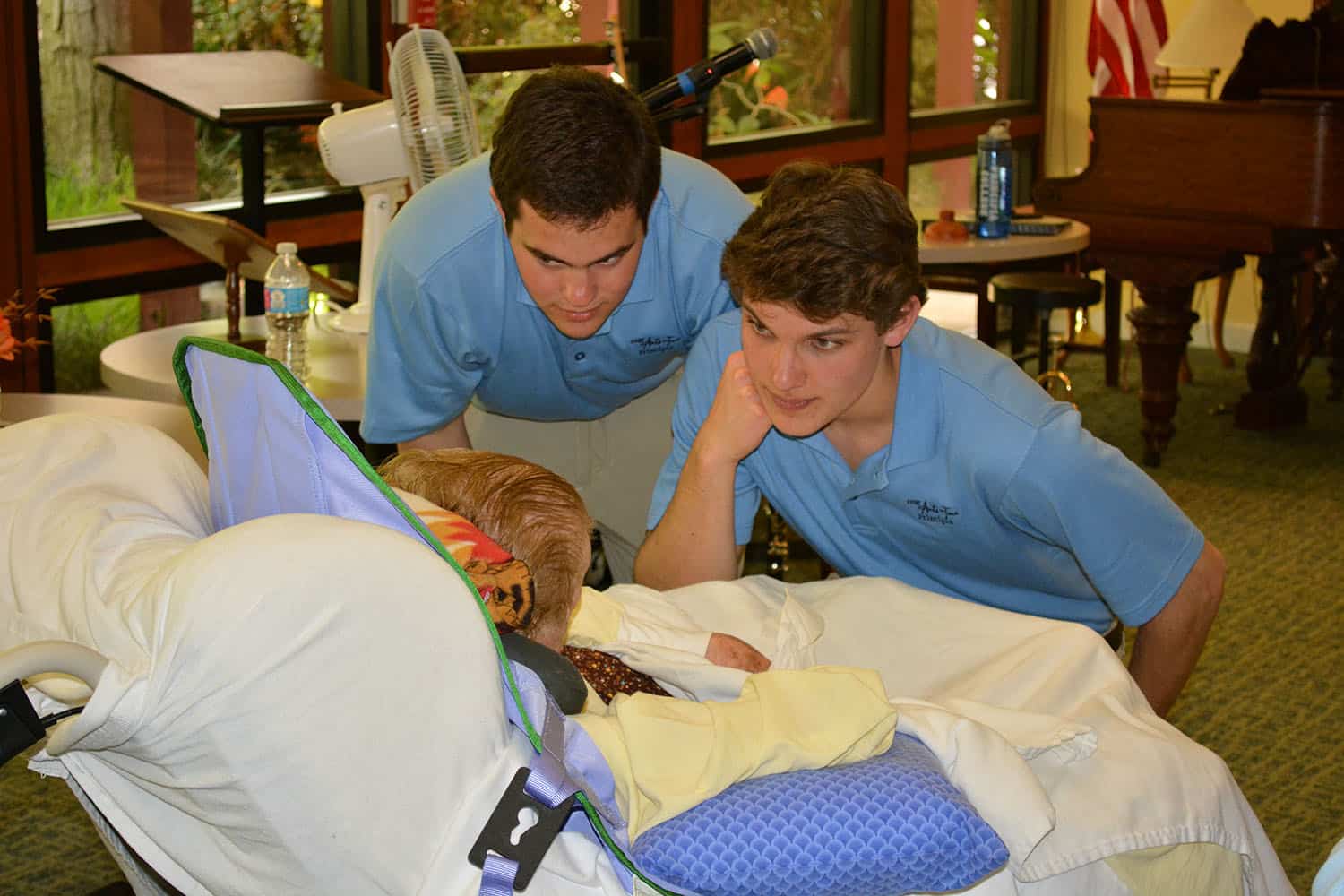 Two Arts on Tour members speak with a Broadview guest resting in bed.