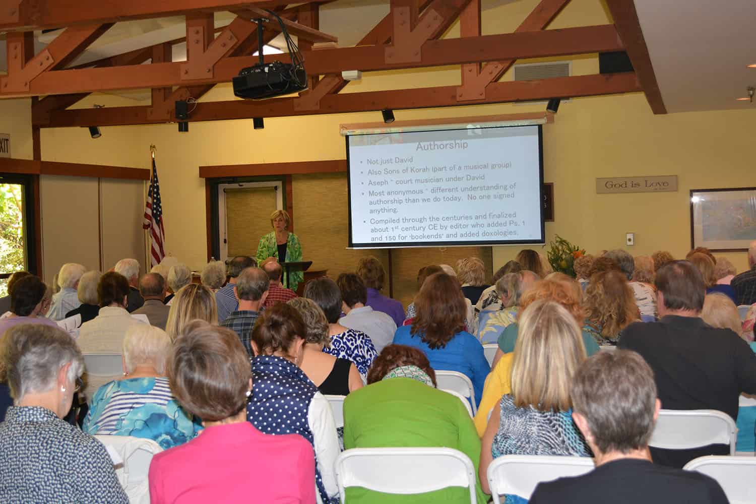A presenter speaks to a full Psalms workshop audience beneath a projected slide about authorship.