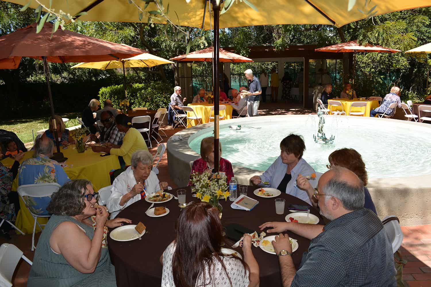 Workshop attendees share lunch around the courtyard fountain.